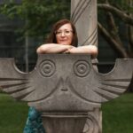 woman sitting on concrete owl seat